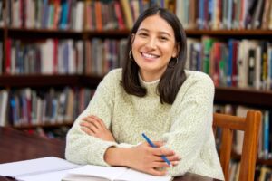 University student in library studying or researching for class.